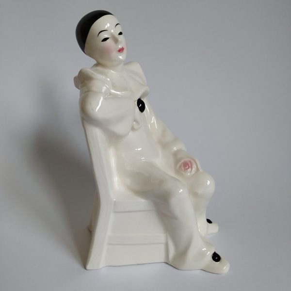 Vintage Pierrot op stoel met een roos in de hand