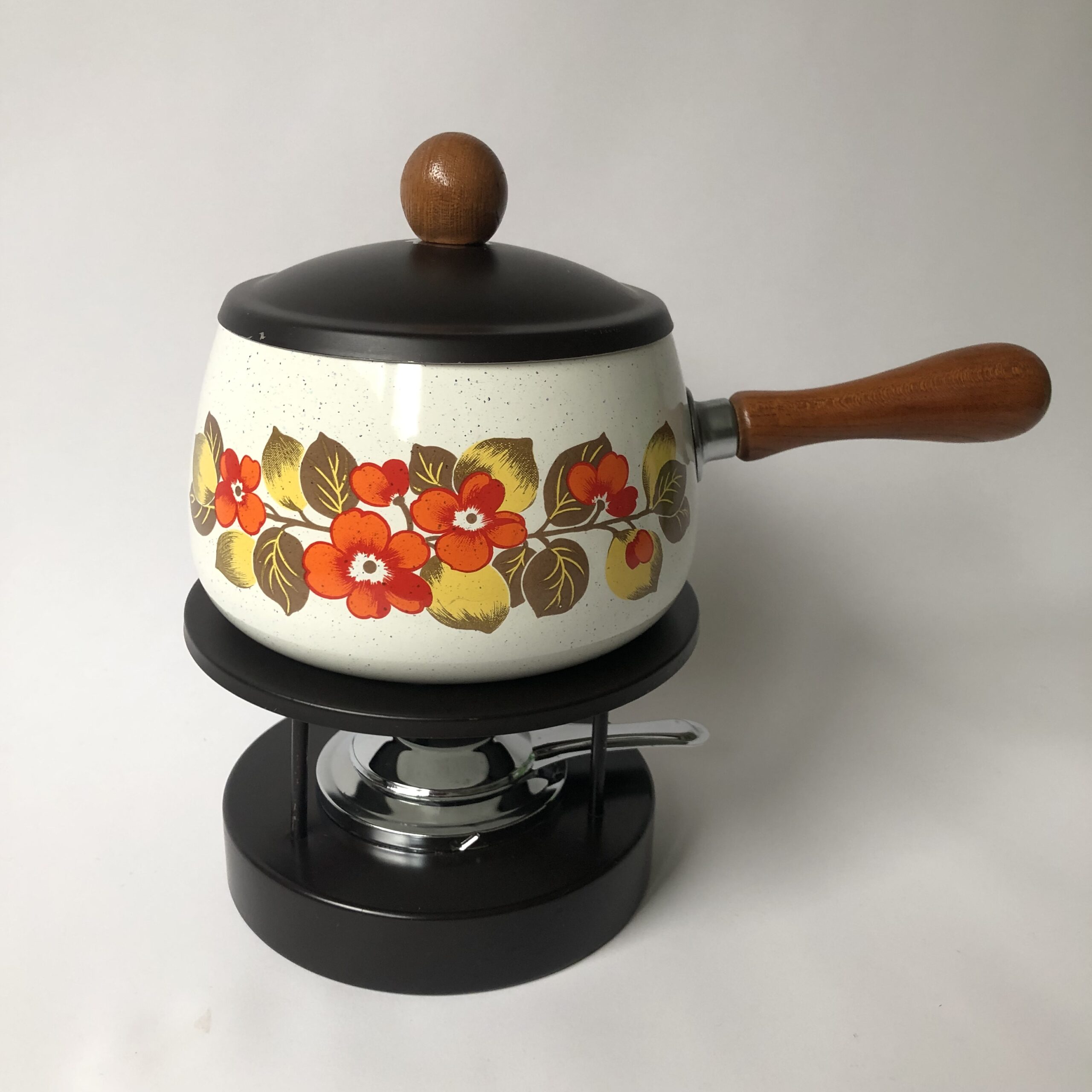 Vintage fondue set, bestaat uit een emaille fonduepan met houten greep/knop en ijzeren onderstel met een brander