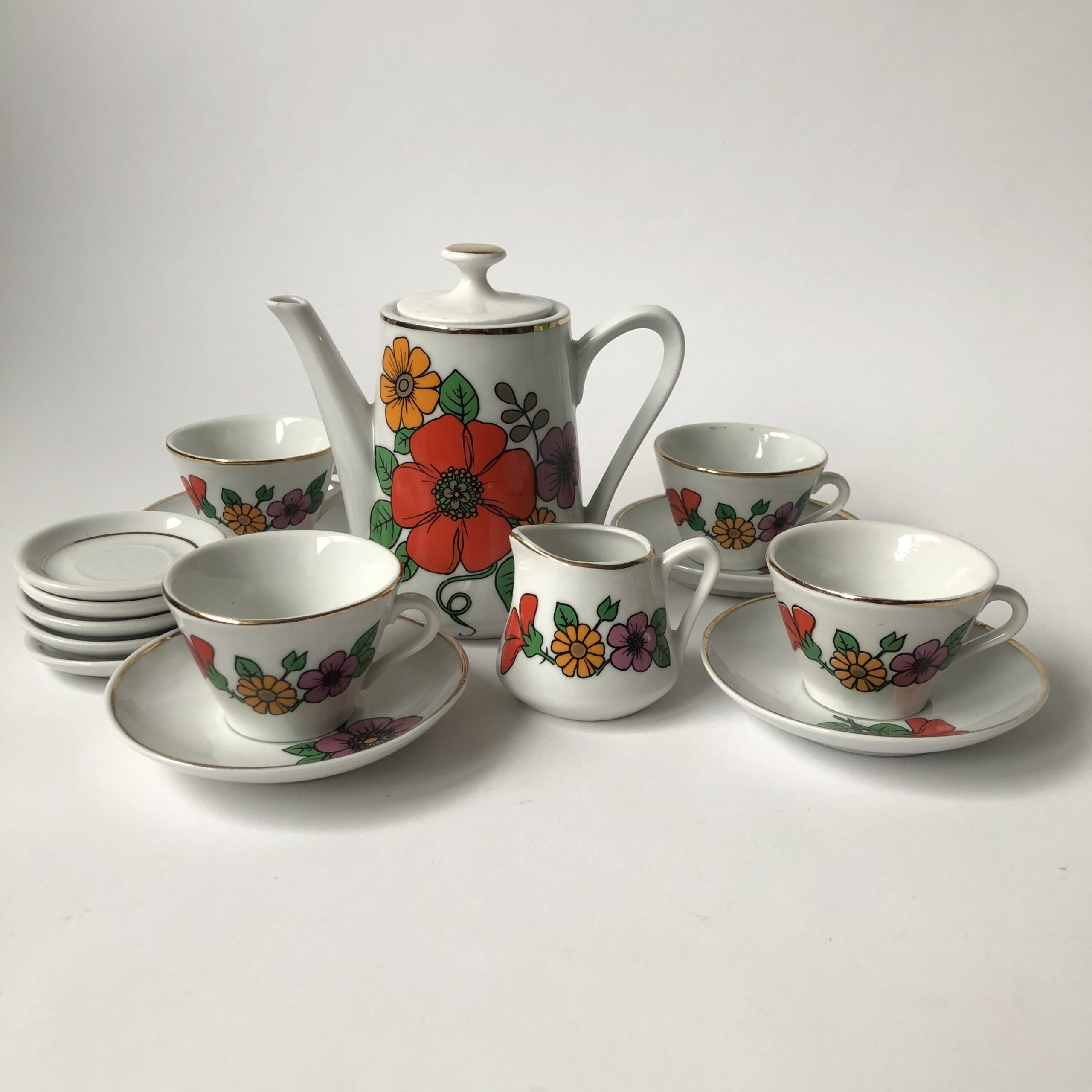 Vintage kinderservies met goudkleurige randen en afbeeldingen van bloemen