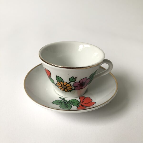 Vintage kinderservies met goudkleurige randen en afbeeldingen van bloemen