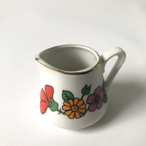 Vintage kinderservies met goudkleurige randen en afbeeldingen van bloemen