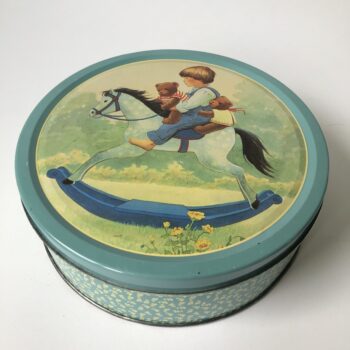 Vintage blik / trommel met als decoratie een kind op een hobbelpaard