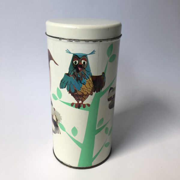 Beschuitbus Fabeltjeskrant uit 1969 - hoogte 22,5 cm - diameter 10,5 cm (1) De Fabeltjeskrant was een populair Nederlands kinderprogramma dat voor het eerst op televisie verscheen in 1968. Het werd bedacht door Leen Valkenier en gemaakt door de Nederlandse televisieproducenten op basis van het idee om een "krant" voor kinderen te creëren met verhalen over dieren in een fantasierijke wereld. De show draaide om de belevenissen van diverse dieren in het dierenbos, die de actualiteit en gebeurtenissen in hun eigen 'wereld' in de vorm van een krant bespraken. De hoofdfiguur was Meneer de Uil, die het nieuws presenteerde en vaak vergezeld werd door andere karakteristieke dieren zoals Juffrouw Ooievaar, Bor de Wolf, en andere kleurrijke figuren. Wat de Fabeltjeskrant bijzonder maakte, was de combinatie van educatieve elementen en humor, evenals de innovatieve manier waarop het gebruikmaakte van poppen en animatie. Het programma was niet alleen geliefd bij kinderen, maar ook bij volwassenen vanwege de scherpe en vaak satirische humor. De show heeft een grote invloed gehad op de Nederlandse kindertelevisie en blijft een nostalgisch icoon voor velen. Na de oorspronkelijke uitzendingen in de jaren '60 en '70, zijn er verschillende pogingen gedaan om het concept nieuw leven in te blazen, waaronder een aantal herhalingen en speciale afleveringen.