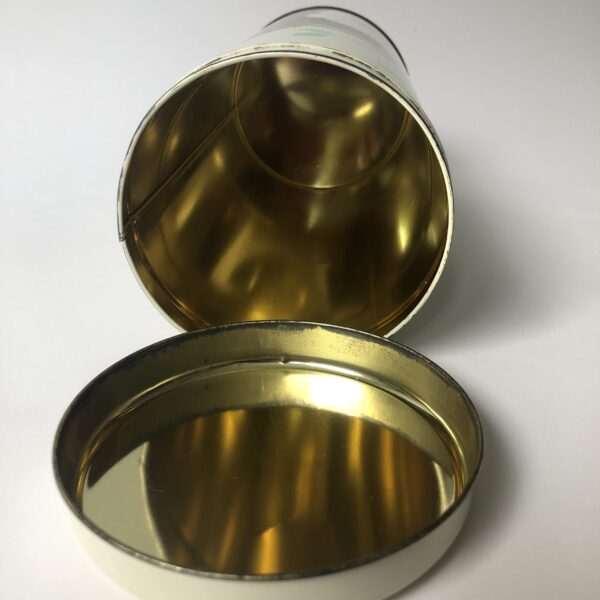 Beschuitbus Fabeltjeskrant uit 1969 - hoogte 22,5 cm - diameter 10,5 cm (4) De Fabeltjeskrant was een populair Nederlands kinderprogramma dat voor het eerst op televisie verscheen in 1968. Het werd bedacht door Leen Valkenier en gemaakt door de Nederlandse televisieproducenten op basis van het idee om een "krant" voor kinderen te creëren met verhalen over dieren in een fantasierijke wereld. De show draaide om de belevenissen van diverse dieren in het dierenbos, die de actualiteit en gebeurtenissen in hun eigen 'wereld' in de vorm van een krant bespraken. De hoofdfiguur was Meneer de Uil, die het nieuws presenteerde en vaak vergezeld werd door andere karakteristieke dieren zoals Juffrouw Ooievaar, Bor de Wolf, en andere kleurrijke figuren. Wat de Fabeltjeskrant bijzonder maakte, was de combinatie van educatieve elementen en humor, evenals de innovatieve manier waarop het gebruikmaakte van poppen en animatie. Het programma was niet alleen geliefd bij kinderen, maar ook bij volwassenen vanwege de scherpe en vaak satirische humor. De show heeft een grote invloed gehad op de Nederlandse kindertelevisie en blijft een nostalgisch icoon voor velen. Na de oorspronkelijke uitzendingen in de jaren '60 en '70, zijn er verschillende pogingen gedaan om het concept nieuw leven in te blazen, waaronder een aantal herhalingen en speciale afleveringen.