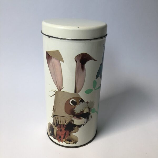 Beschuitbus Fabeltjeskrant uit 1969 - hoogte 22,5 cm - diameter 10,5 cm (5) De Fabeltjeskrant was een populair Nederlands kinderprogramma dat voor het eerst op televisie verscheen in 1968. Het werd bedacht door Leen Valkenier en gemaakt door de Nederlandse televisieproducenten op basis van het idee om een "krant" voor kinderen te creëren met verhalen over dieren in een fantasierijke wereld. De show draaide om de belevenissen van diverse dieren in het dierenbos, die de actualiteit en gebeurtenissen in hun eigen 'wereld' in de vorm van een krant bespraken. De hoofdfiguur was Meneer de Uil, die het nieuws presenteerde en vaak vergezeld werd door andere karakteristieke dieren zoals Juffrouw Ooievaar, Bor de Wolf, en andere kleurrijke figuren. Wat de Fabeltjeskrant bijzonder maakte, was de combinatie van educatieve elementen en humor, evenals de innovatieve manier waarop het gebruikmaakte van poppen en animatie. Het programma was niet alleen geliefd bij kinderen, maar ook bij volwassenen vanwege de scherpe en vaak satirische humor. De show heeft een grote invloed gehad op de Nederlandse kindertelevisie en blijft een nostalgisch icoon voor velen. Na de oorspronkelijke uitzendingen in de jaren '60 en '70, zijn er verschillende pogingen gedaan om het concept nieuw leven in te blazen, waaronder een aantal herhalingen en speciale afleveringen.