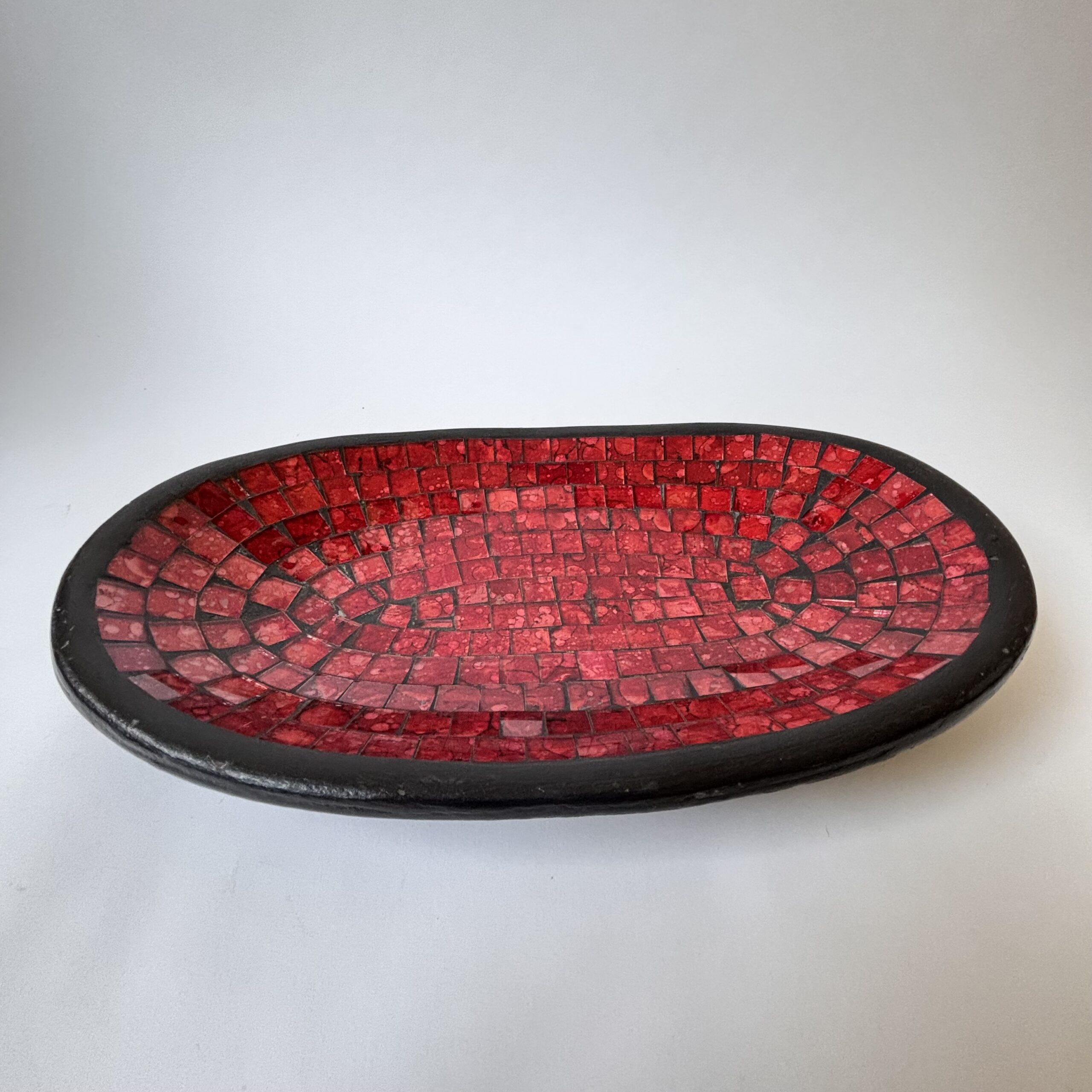 Deze fraaie decoratieve schaal is een mozaïek van aardewerk en rood glas