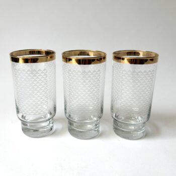 Vintage glazen met een goudkleurige rand en aan voor en achterzijde een motief